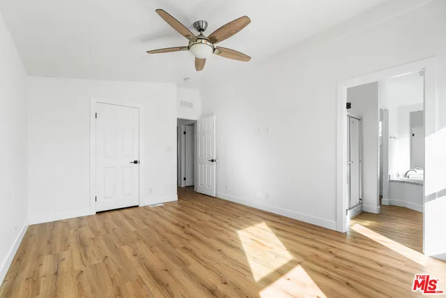 a view of a big room with wooden floor and a ceiling fan