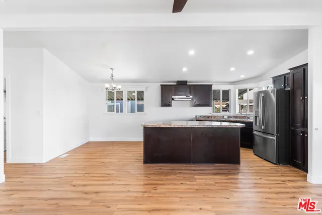 a large kitchen with stainless steel appliances granite countertop a refrigerator and a stove top oven