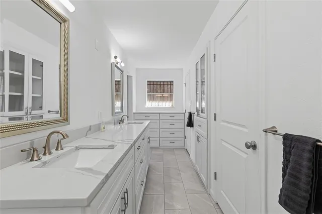 a bathroom with double vanity and a bathtub