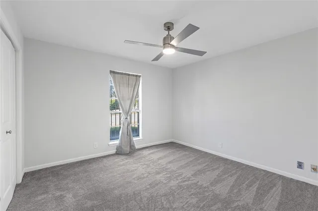 an empty room with fan and windows