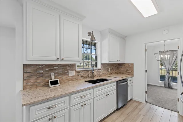 a kitchen with stainless steel appliances granite countertop a sink stove and cabinets