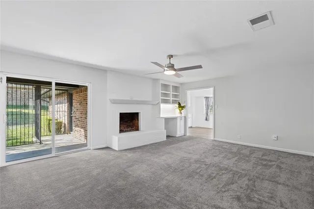 a view of a livingroom with a fireplace and a ceiling fan