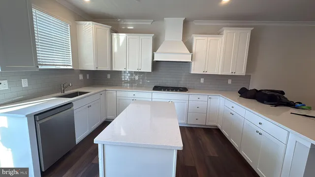 a kitchen with white cabinets appliances and sink