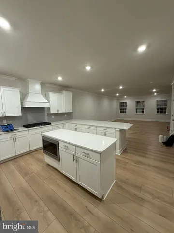 a large kitchen with stainless steel appliances granite countertop a large counter top a stove and a sink