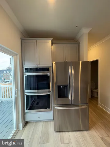 a view of a refrigerator in kitchen and wooden floor