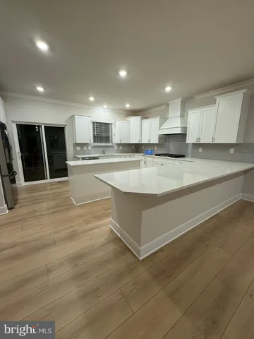 a large kitchen with kitchen island a sink stainless steel appliances and cabinets