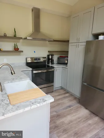 a kitchen with granite countertop a sink stove and refrigerator