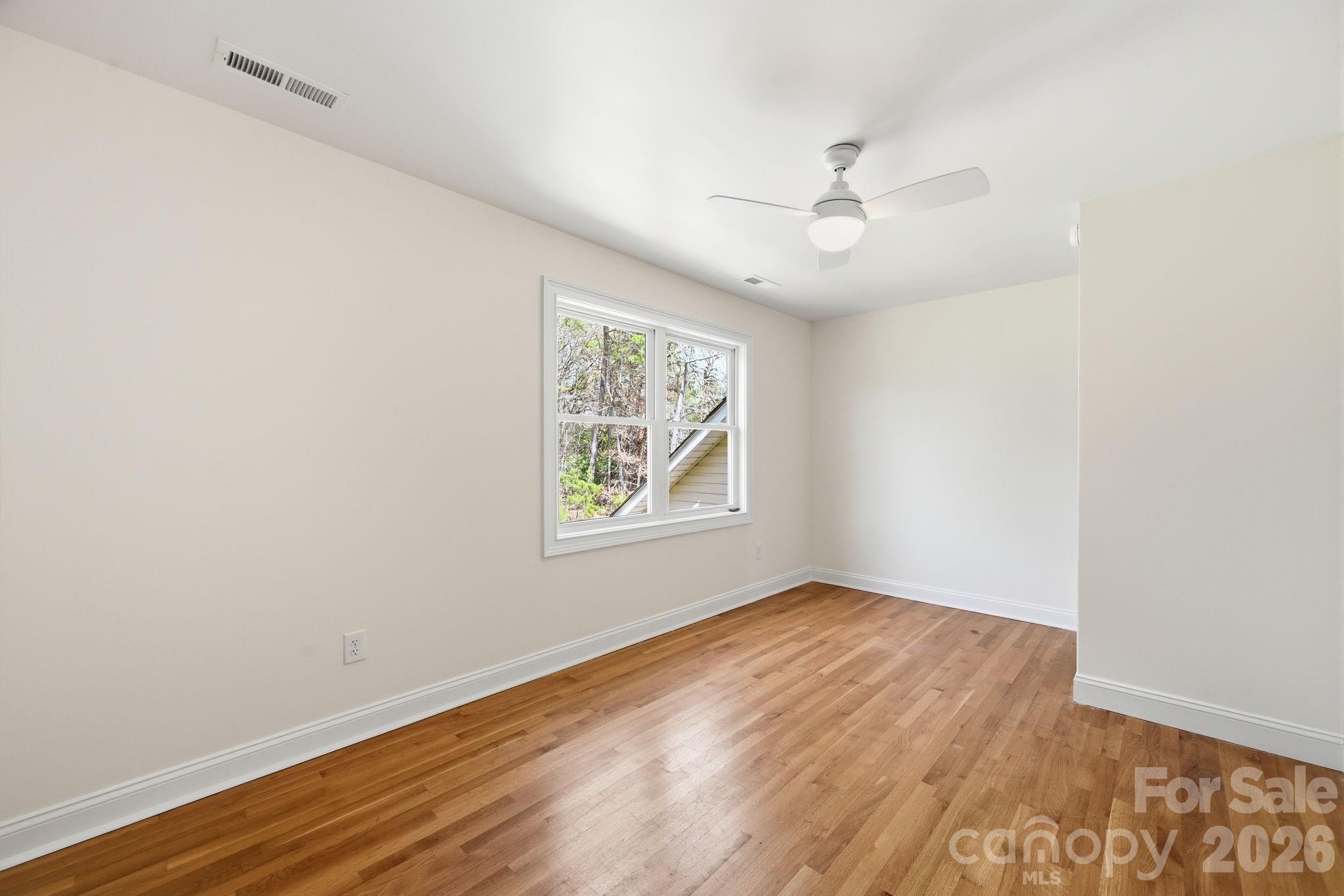 166 Ridge Run Drive Statesville, NC 28625 - Photo 16 of 19 an empty room with wooden floor ceiling fan and windows