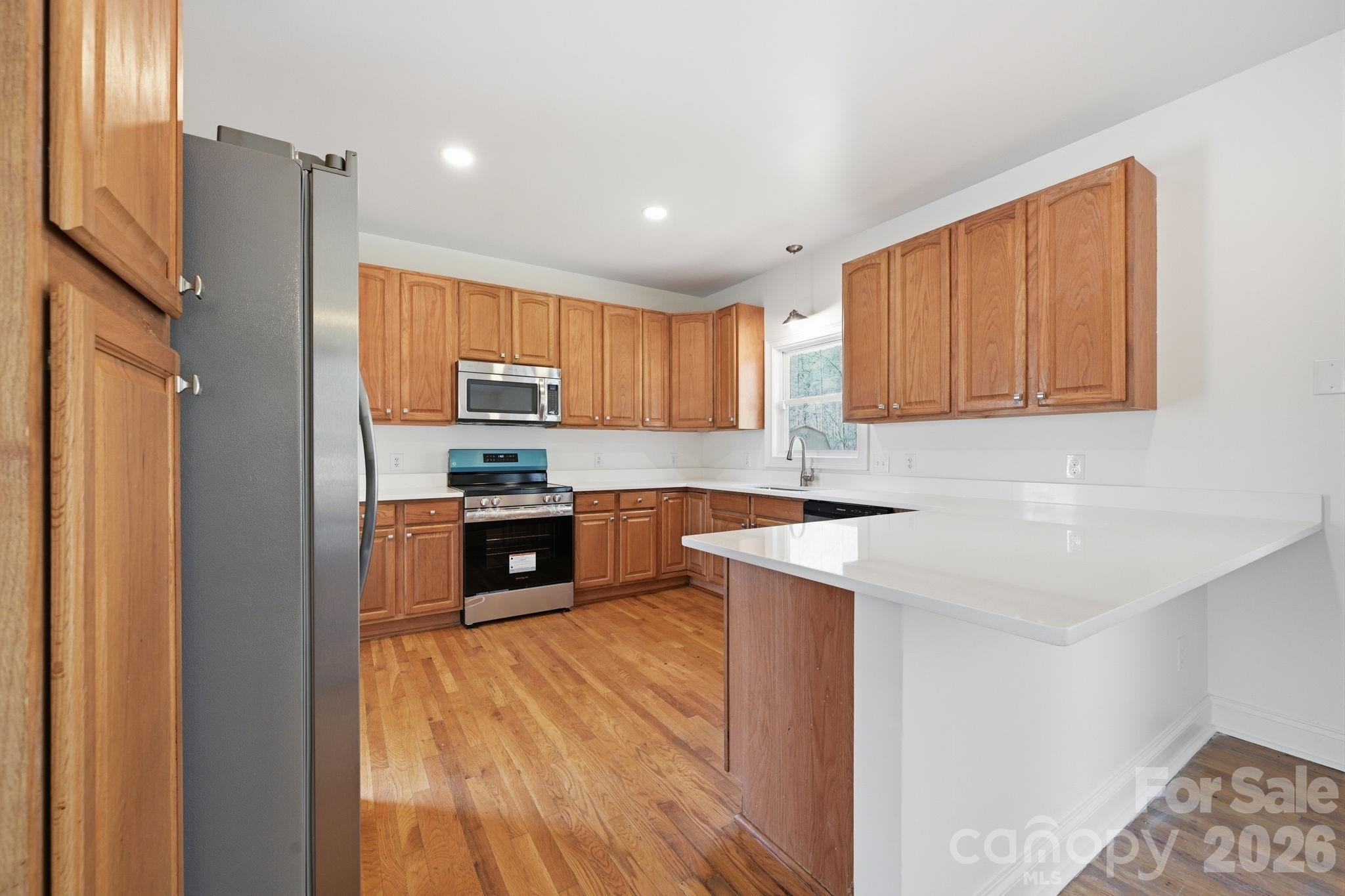 166 Ridge Run Drive Statesville, NC 28625 - Photo 4 of 19 a kitchen with stainless steel appliances granite countertop a stove a sink and a refrigerator with wooden floor