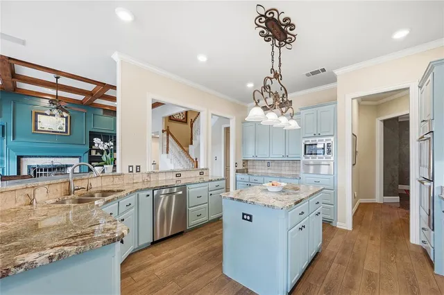 a kitchen with a sink stove and wooden floor
