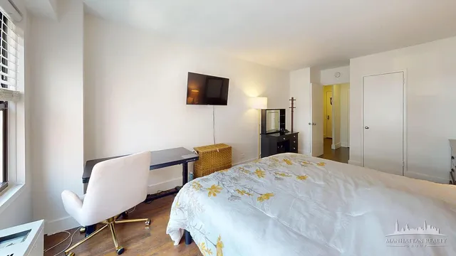 a bedroom with a bed and a television