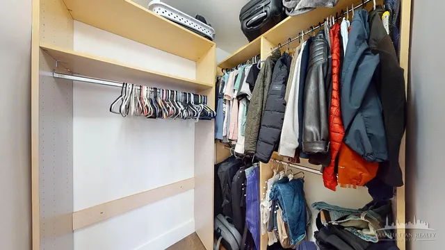 a view of walk in closet with clothes and shoes
