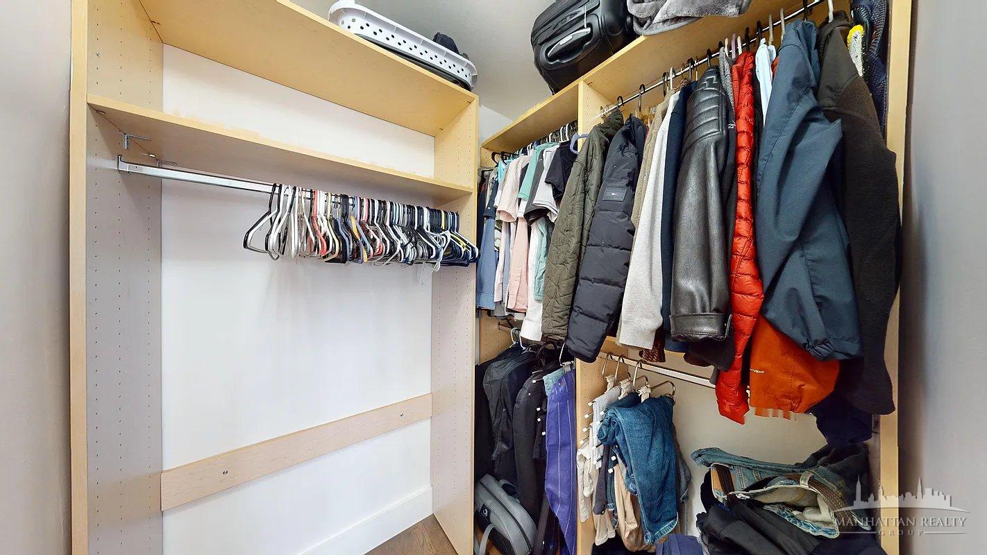 220 East 63rd Street, Unit 8J Manhattan, NY 10023 - Photo 5 of 14 a view of walk in closet with clothes and shoes