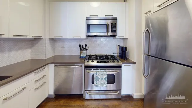 a kitchen with stainless steel appliances a stove a microwave and a refrigerator