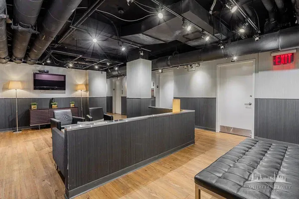 a media room with lots of chairs and a wooden floor