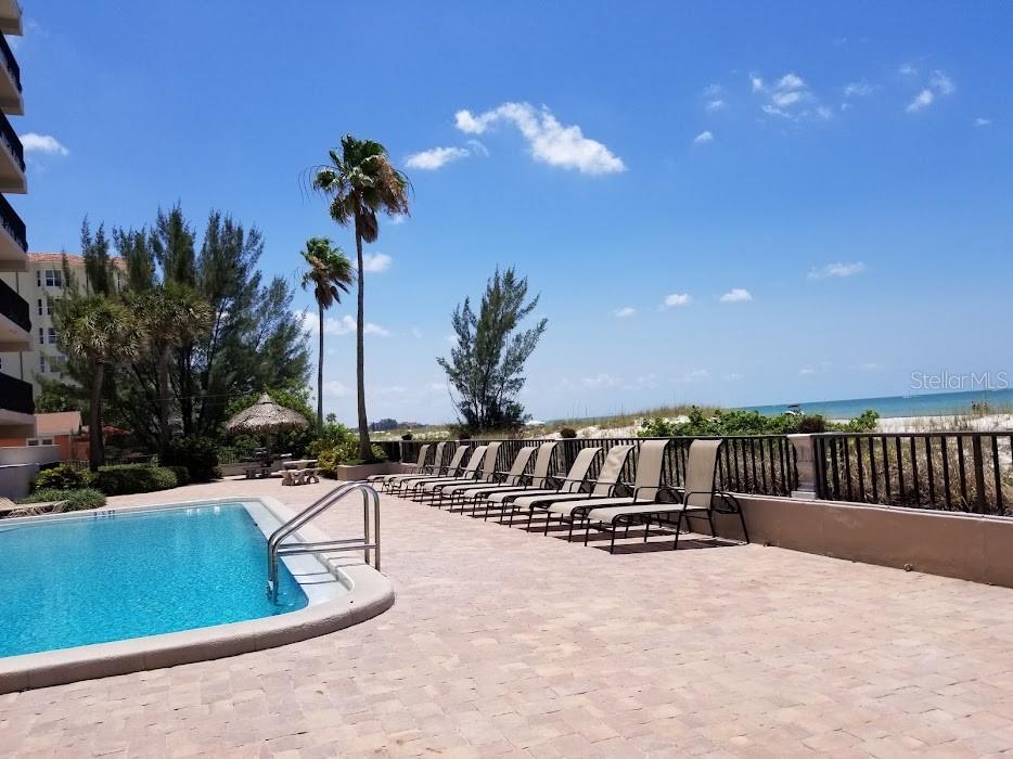 13650 Gulf Boulevard, Unit 304 Madeira Beach, FL 33708 - Photo 62 of 63 a view of swimming pool with outdoor seating and plants