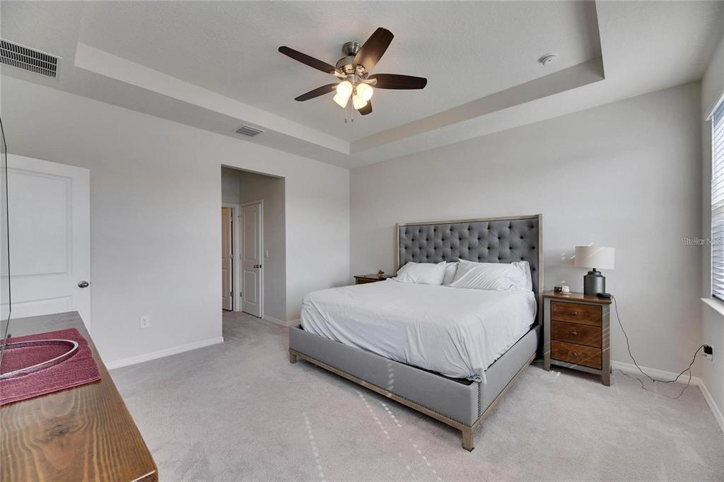 5125 Tannin Lane Lakewood Ranch, FL 34211 - Photo 13 of 45 a bedroom with a bed chandelier and a couch