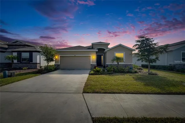 a front view of a house with a garden and yard