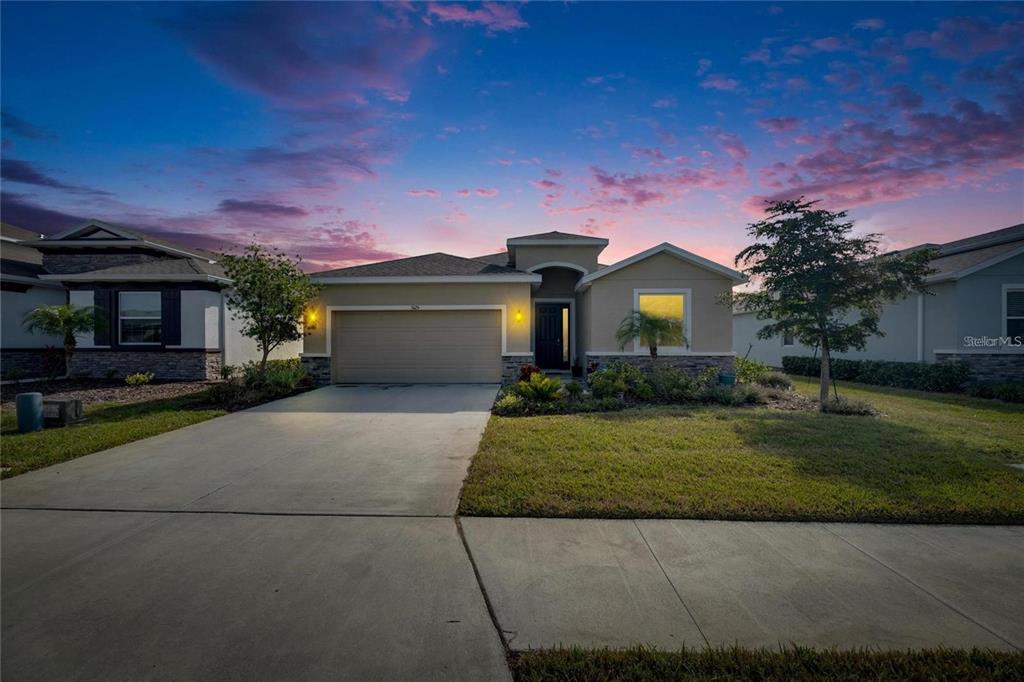 5125 Tannin Lane Lakewood Ranch, FL 34211 - Photo 2 of 45 a front view of a house with a garden and yard