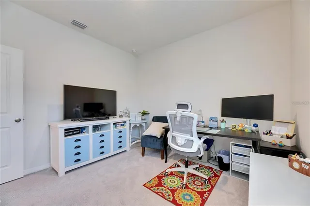a view of a workspace with furniture and a flat screen tv