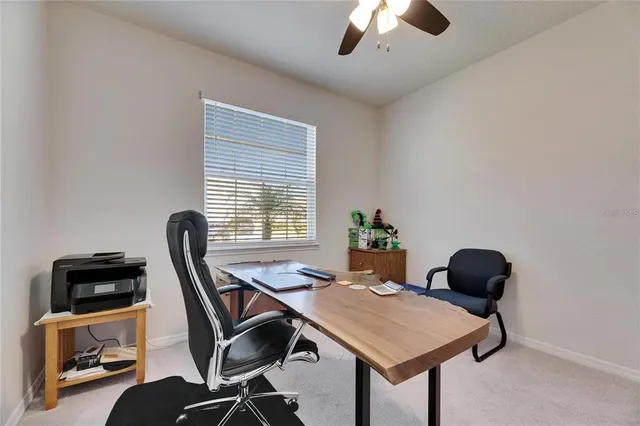 a view of a workspace with furniture and a window