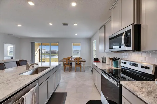 a large kitchen with stainless steel appliances granite countertop a lot of counter space a sink and dishwasher