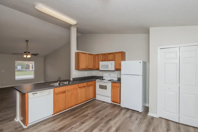 a kitchen with a sink a refrigerator and cabinets
