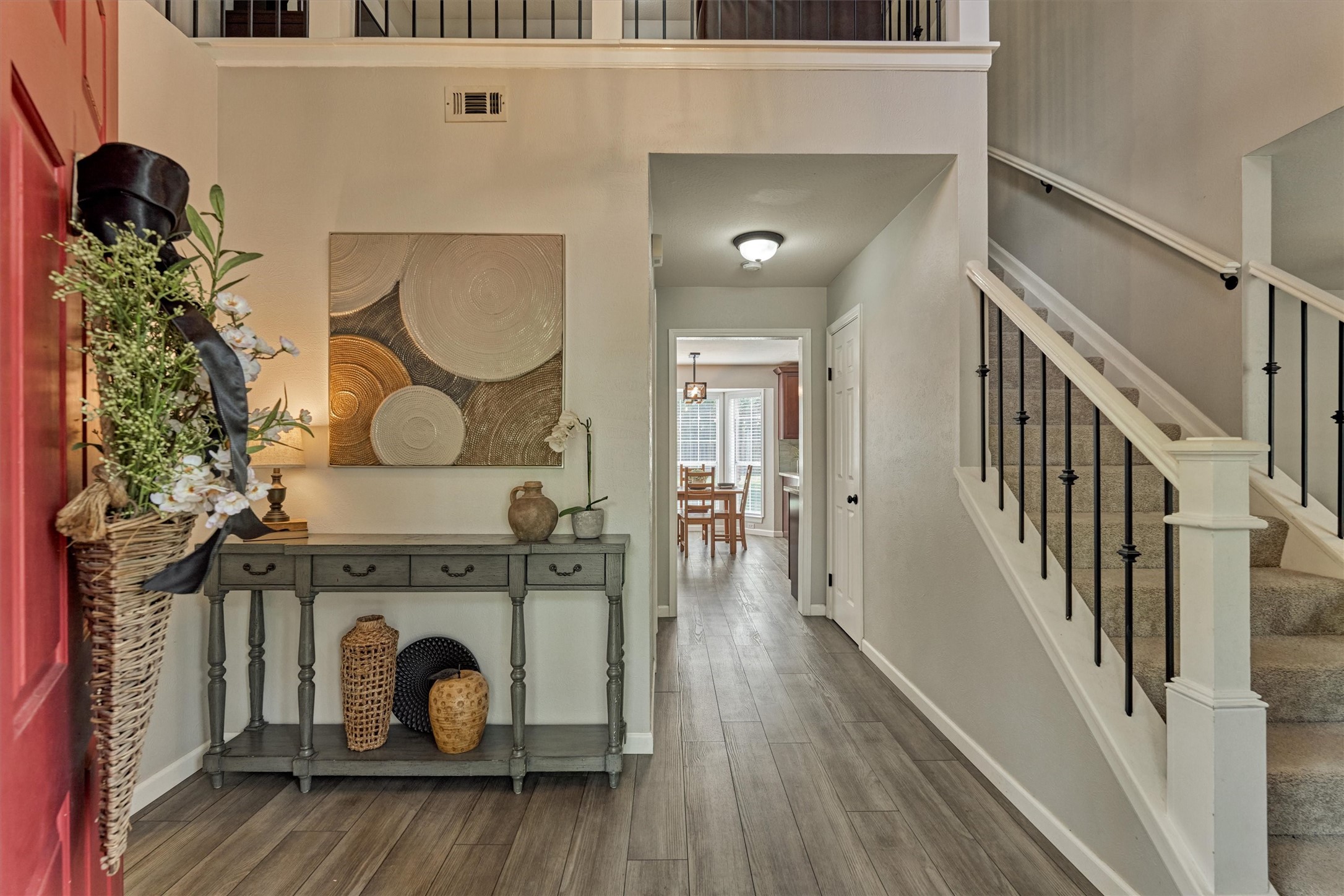 19 Greentwig Place Spring, TX 77381 - Photo 3 of 37 Light, bright, cozy with a touch of sophistication! View from front door. Met with a stunning entry area, hallway to half bath and breakfast room with stairs on the right. Dining room is beyond stairs.