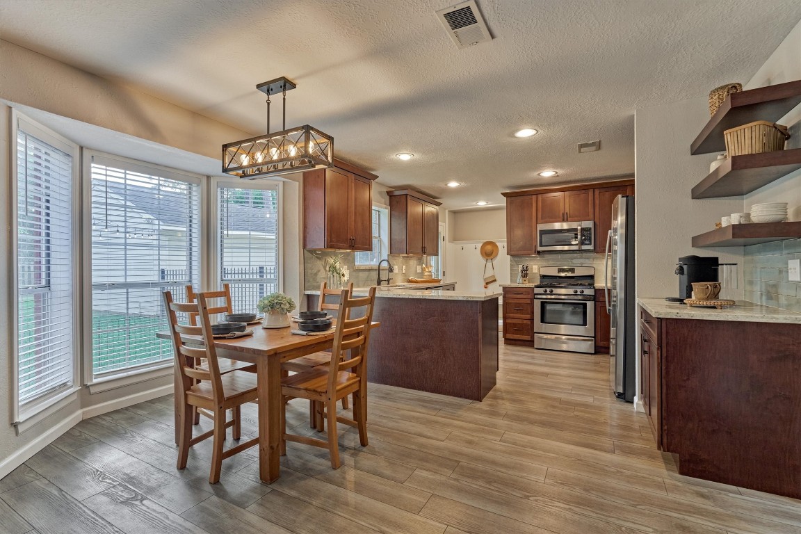 19 Greentwig Place Spring, TX 77381 - Photo 9 of 37 Breakfast area with coffee bar, open shelving, updated lighting and open to kitchen.