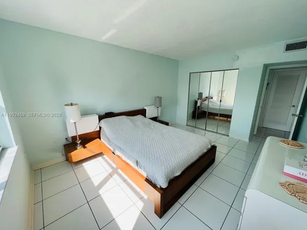 a bed sitting in a bedroom and mirror