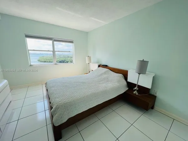 a bedroom with a bed and a lamp on table