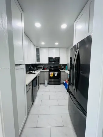 a kitchen with granite countertop stainless steel appliances and refrigerator