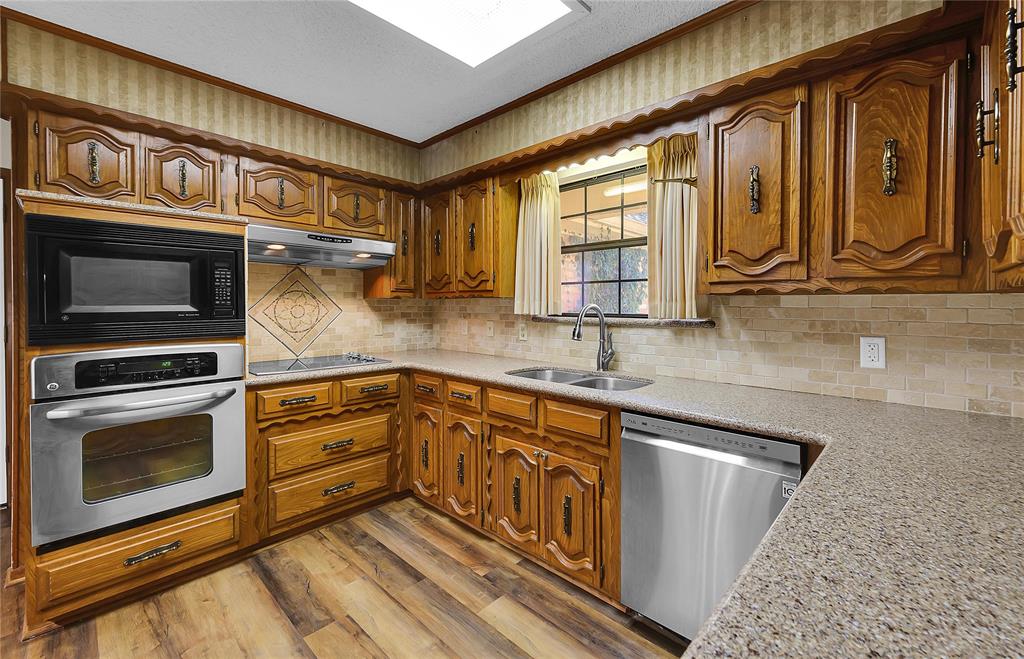 210 Chelsea Drive Hewitt, TX 76643 - Photo 11 of 36 a kitchen with granite countertop a stove a sink and a microwave