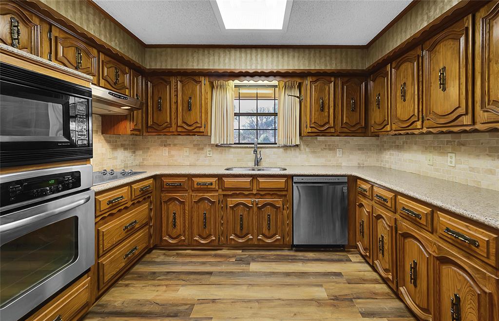 210 Chelsea Drive Hewitt, TX 76643 - Photo 10 of 36 a kitchen with stainless steel appliances granite countertop a stove a sink and a microwave