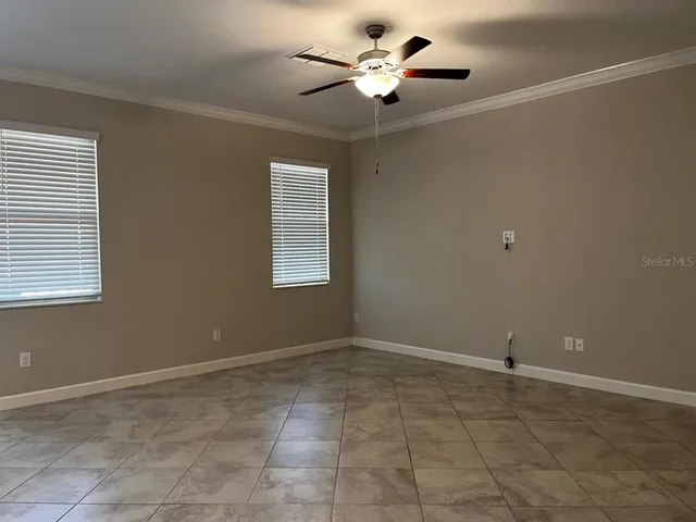 a view of an empty room with a ceiling fan and a window