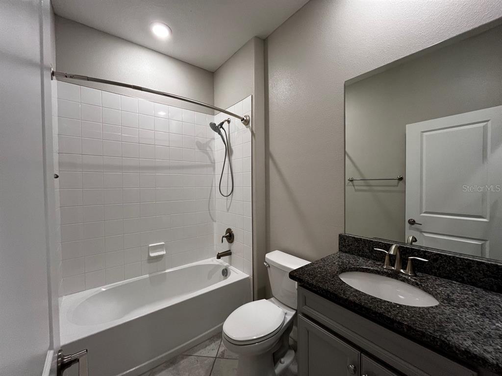 25195 Lambrusco Loop Lutz, FL 33559 - Photo 26 of 36 a bathroom with a granite countertop sink toilet mirror and shower