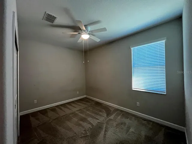a view of empty room with ceiling fan