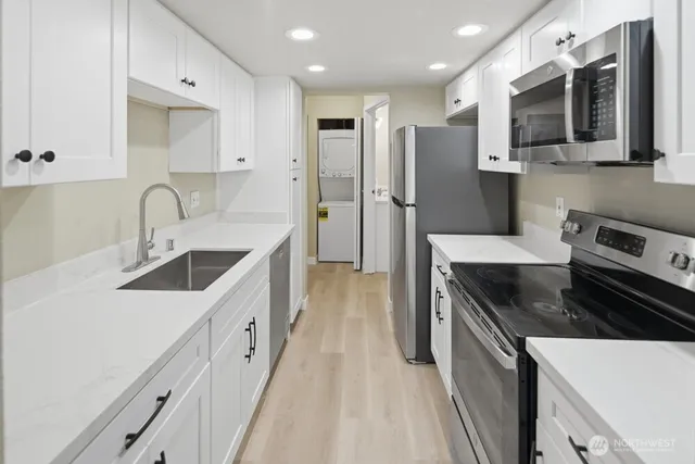 a kitchen with stainless steel appliances granite countertop a sink stove and refrigerator