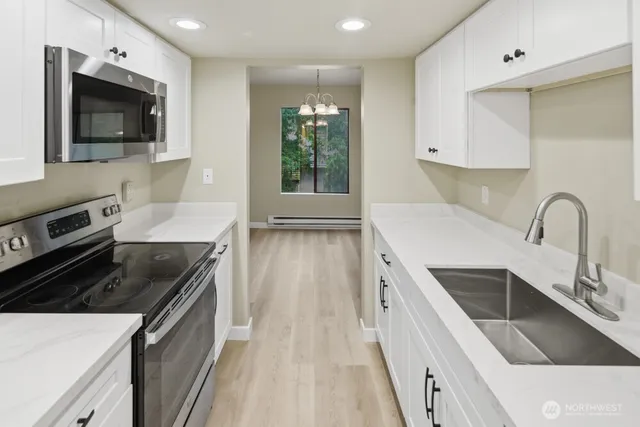 a kitchen with a sink a microwave and cabinets