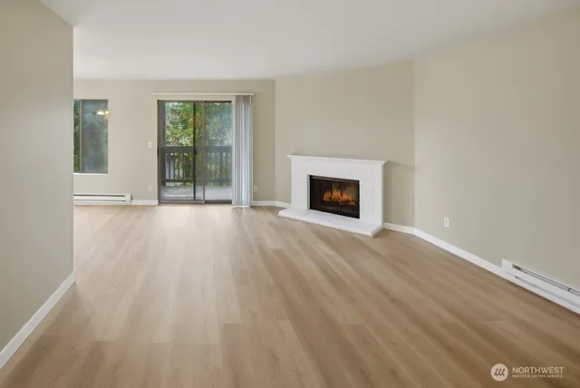 a view of an empty room with glass door and a window