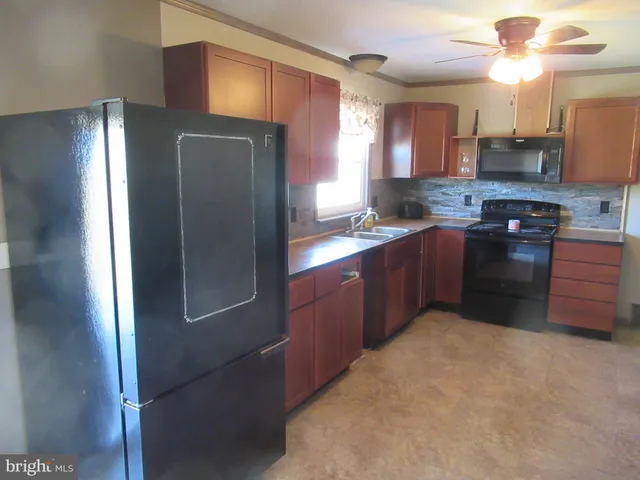 a kitchen with stainless steel appliances granite countertop a refrigerator a stove a sink and dishwasher