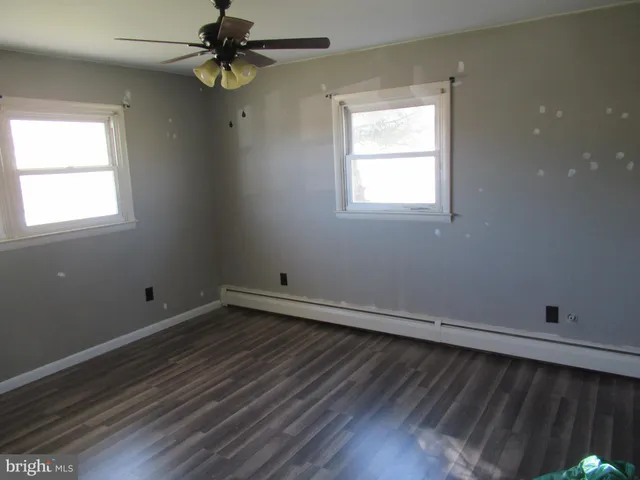 an empty room with a window and a ceiling fan