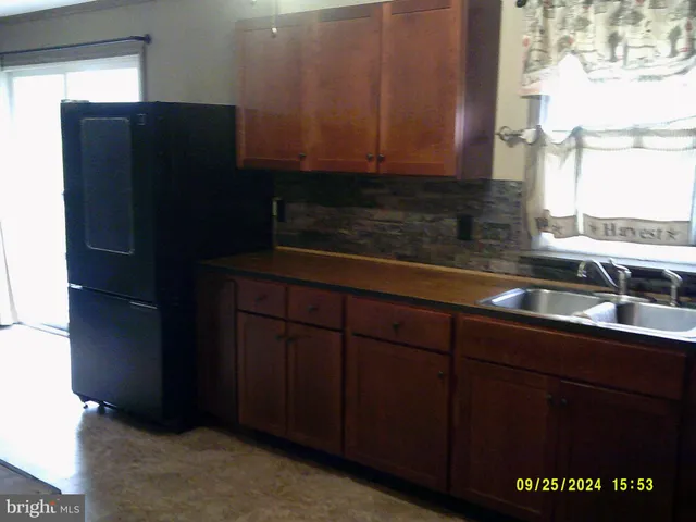 a kitchen with stainless steel appliances granite countertop wood cabinets and a sink