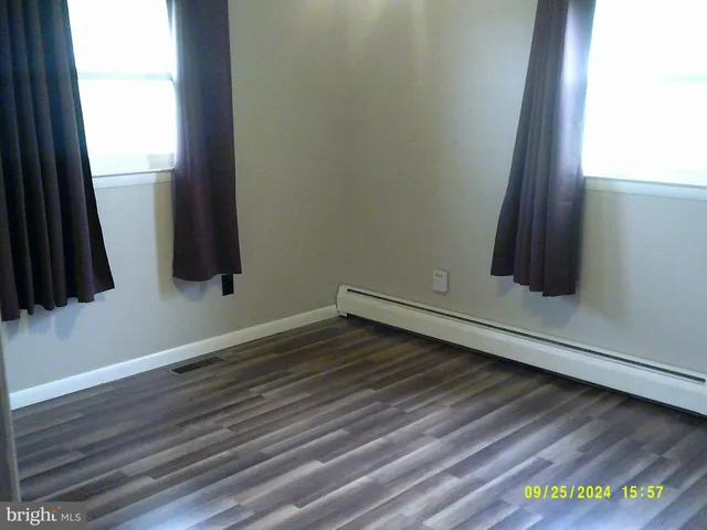 a view of an empty room with wooden floor