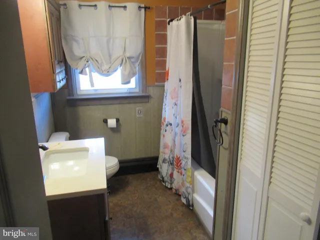 a bathroom with a toilet and a shower curtain