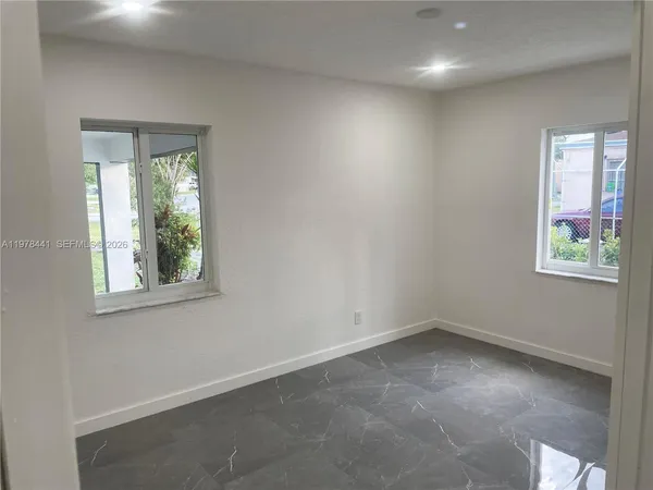 an empty room with windows and closet