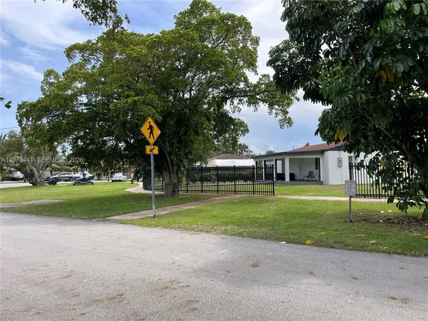 a front view of a house with a yard and trees