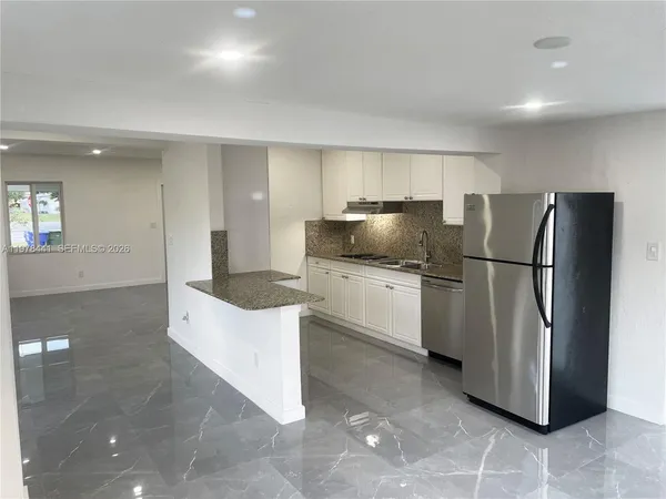 a kitchen with stainless steel appliances a refrigerator sink and cabinets