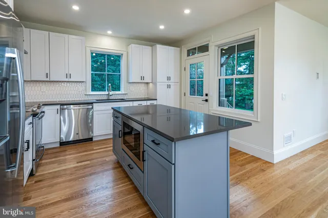 a kitchen with stainless steel appliances granite countertop a sink stove and wooden floor