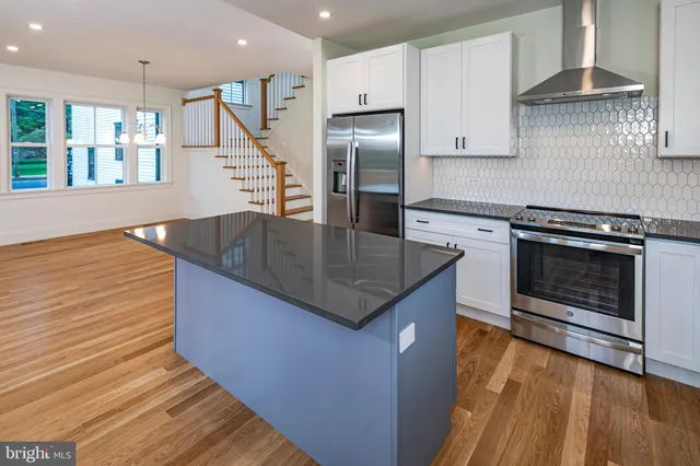 a kitchen with stainless steel appliances granite countertop a stove a refrigerator and a sink